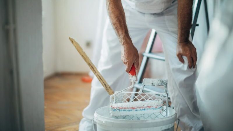 Pintor mezclando pintura para mantenimiento de edificio