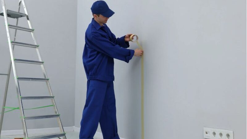 Operario midiendo pared en reforma integral